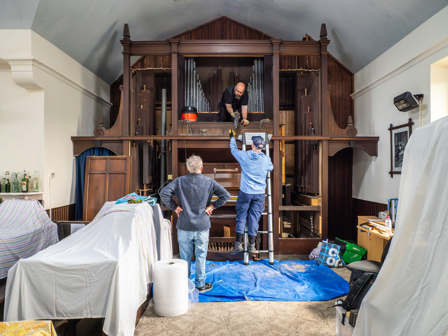 Workers dismantling the pipe organ inside Crawfordjohn Heritage Venture Museum